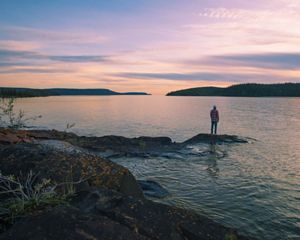 A man stands on an island in Christie Bay, one of the entry points to Thaidene Nene National Park Reserve.