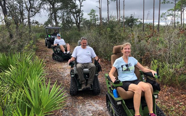 Volunteers trying track chairs in Tiger Creek Preserve to improve the trails accessibility.