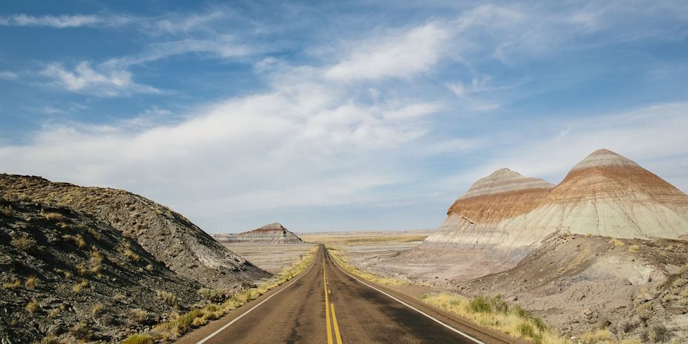 a view of an empty road through a desert.