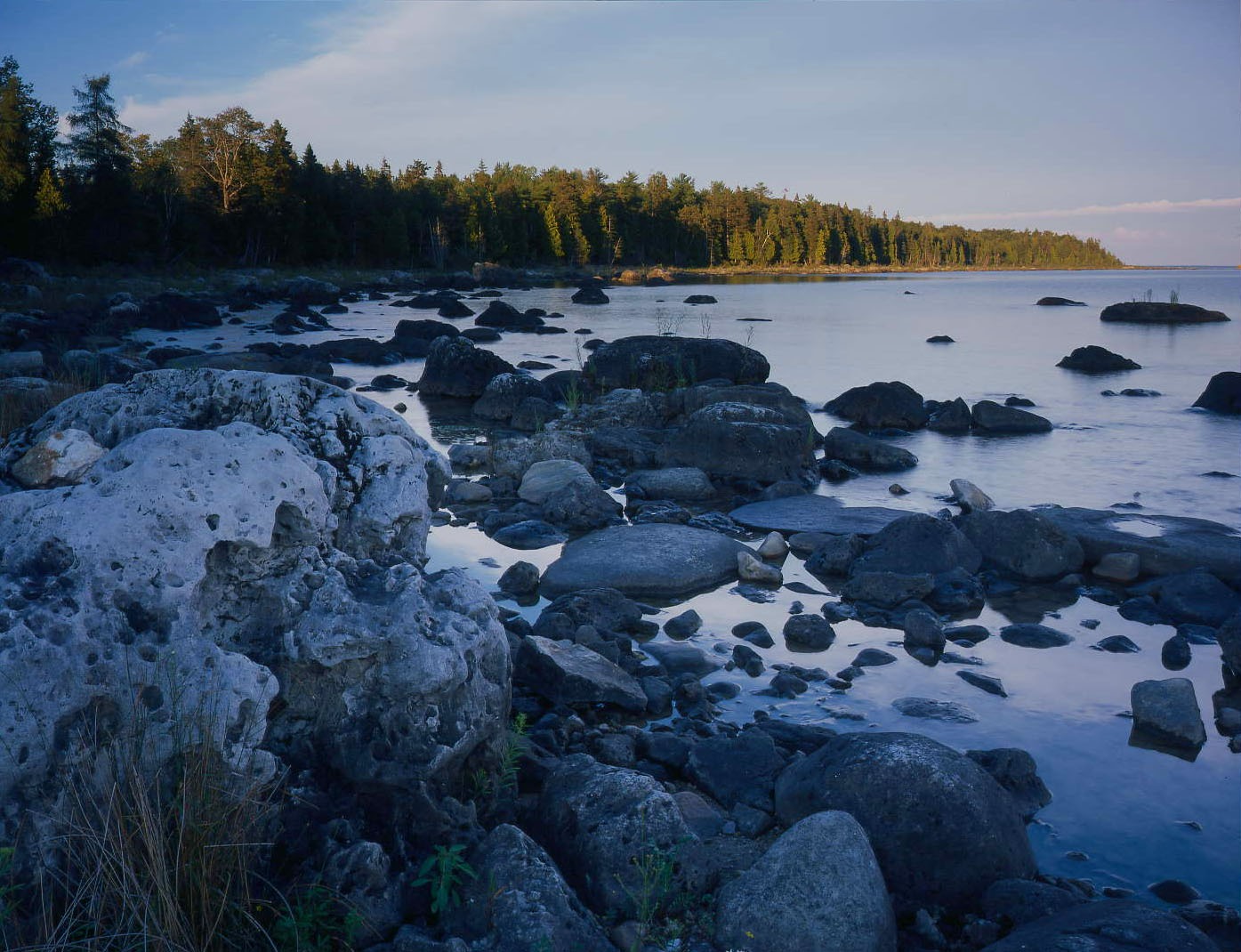 A rocky lake shore at dusk.