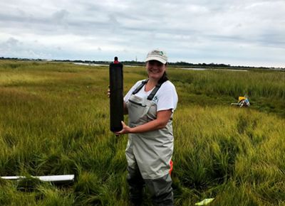 Nicole Maher poses with a salt marsh core sample.